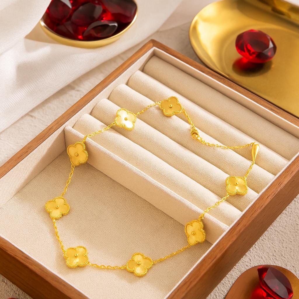 VCA Necklace featuring delicate gold floral motifs arranged on a fine chain, displayed in a beige cushioned wooden jewelry box for an elegant presentation.