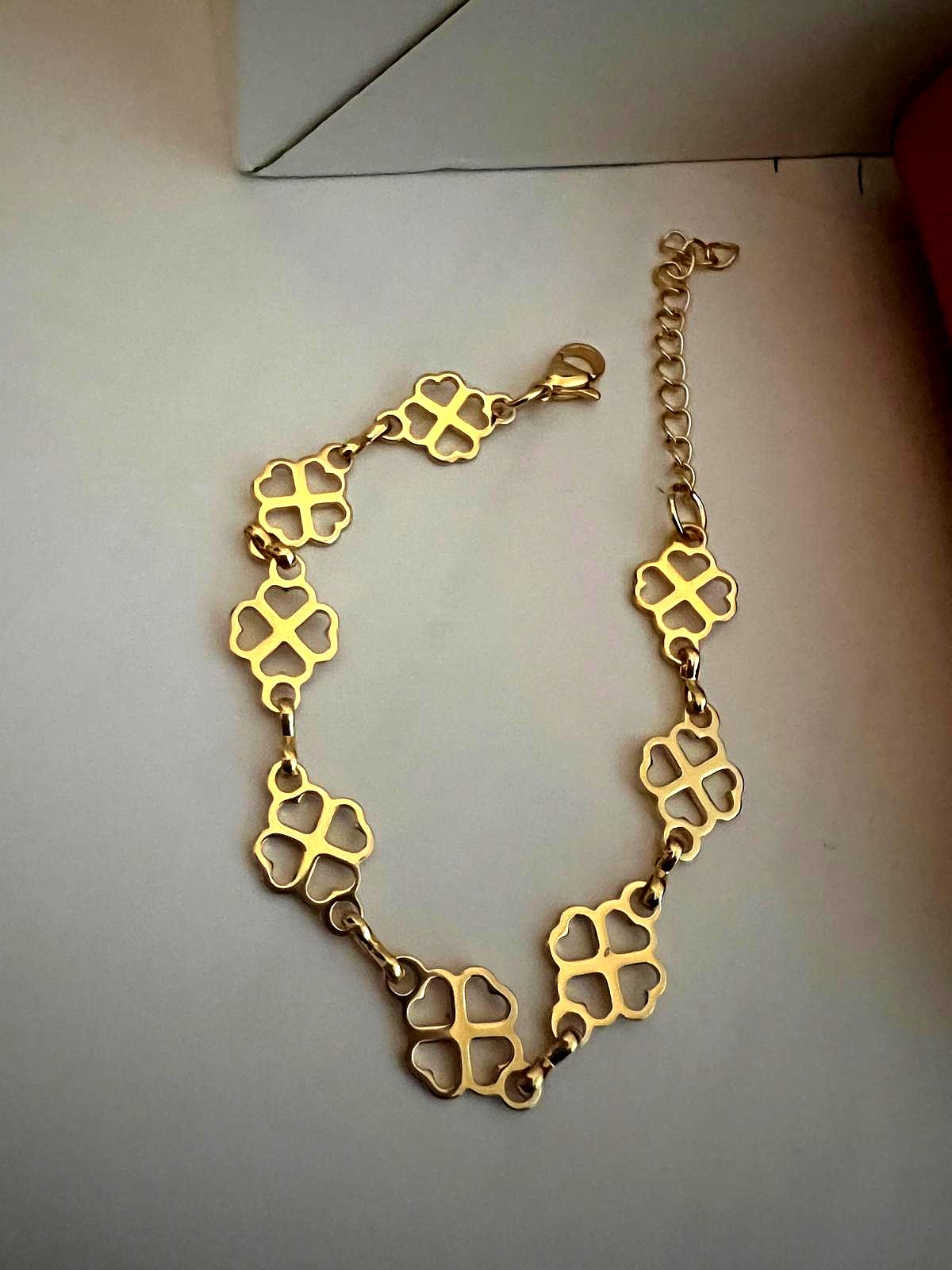 Clover Bracelet featuring delicate gold clover-shaped links connected by small rings, designed as an elegant and stylish luxury accessory.