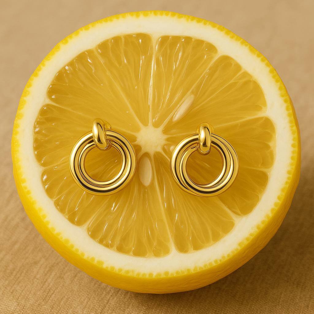 Gold tone double circle Cute stud earrings displayed on a fresh lemon half, highlighting their shiny, minimalist design perfect for everyday luxury accessories.