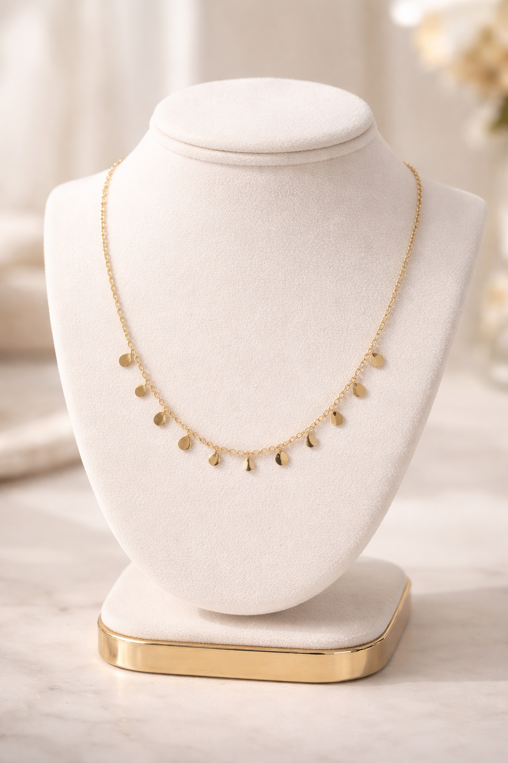 Delicate Gold Layering Necklace displayed on a white velvet bust, featuring small round gold charms spaced evenly along a fine gold chain, creating an elegant and minimalistic look.