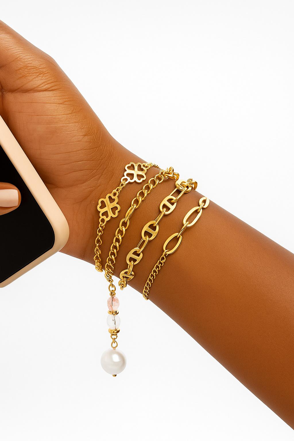Close-up of a wrist adorned with the Baddie Bracket Stack featuring multiple elegant 18K gold plated bracelets including chain links, floral motifs, and a pearl charm, showcasing luxury accessories.