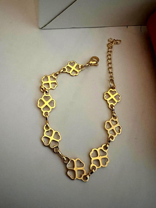 Clover Bracelet featuring delicate gold clover-shaped links connected by small rings, designed as an elegant and stylish luxury accessory.